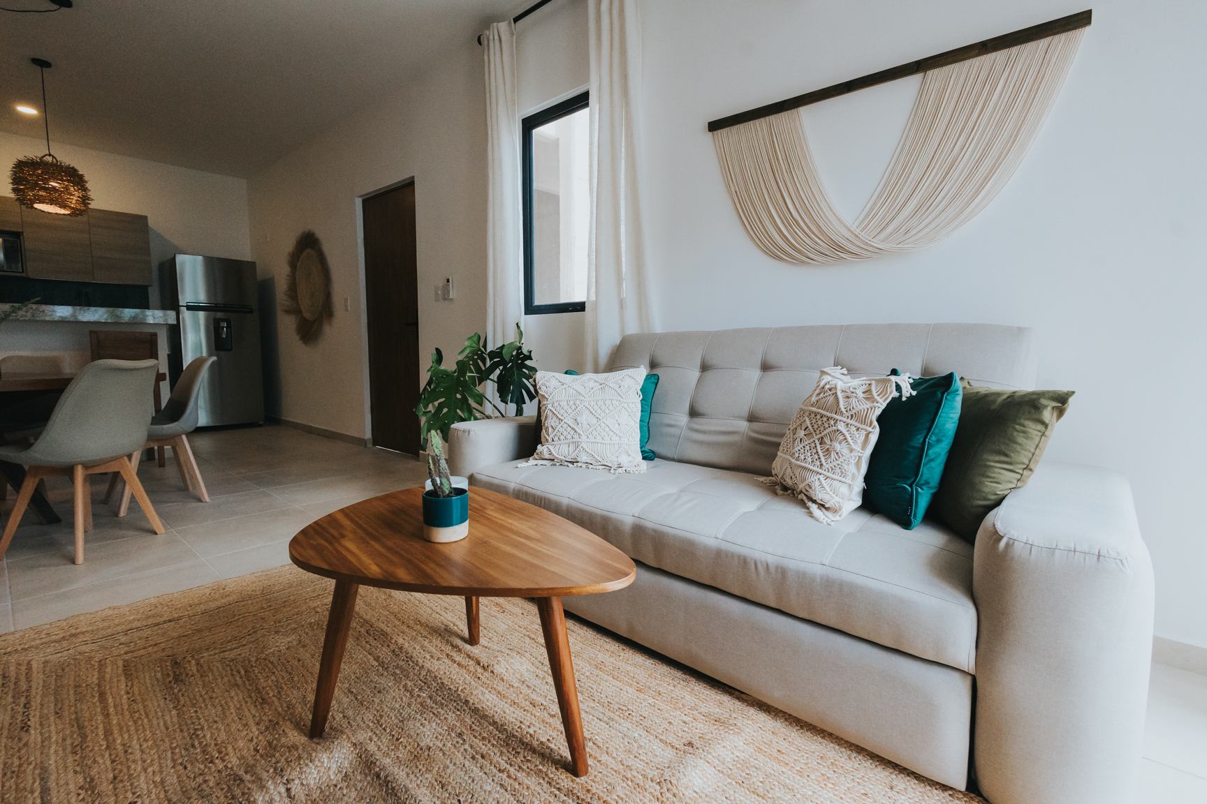 Casa del Marquis — soft neutral living room with macramé wall hanging and jute rug